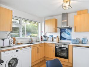 une cuisine avec une machine à laver et un lave-linge dans l'établissement Liwus, à Newquay