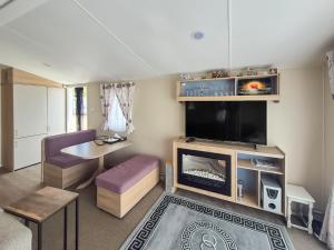 Una sala de estar con chimenea y televisión. en Seaside Retreat, en South Hayling