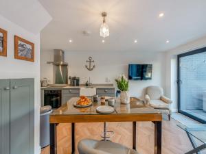 a kitchen with a table with a bowl of fruit on it at Harbour Lodge - Uk49490 in Whitstable
