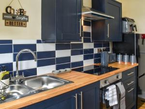 a kitchen with a sink and blue and white tiles at Ocean Breeze in Heysham +23 photos