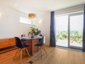 ein Esszimmer mit Tisch und Stühlen und einem großen Fenster in der Unterkunft Lower Mount Orchard in Stroud