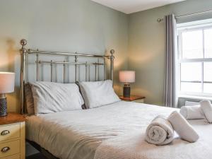 Un dormitorio con una cama grande con toallas. en High Tide - Uk50361, en Filey