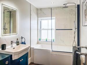 Un baño con bañera, lavabo y ducha. en High Tide - Uk50361, en Filey 7 fotos más