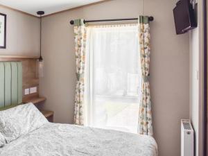 een slaapkamer met een bed en een raam bij Seaview One - Uk50167 in Corton