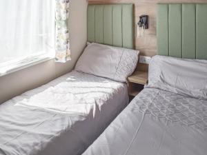 een slaapkamer met twee bedden en een raam bij Seaview One - Uk50167 in Corton