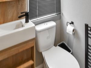 een badkamer met een wit toilet en een wastafel bij Seaview One - Uk50167 in Corton +7 foto's