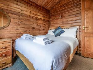 a bedroom with a bed in a log cabin at Tamnavulin Lodge - Uk49121 in Feshiebridge