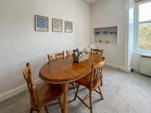 a dining room with a wooden table and chairs at Glenfyne Apartment - Uk49318 in Ardrishaig