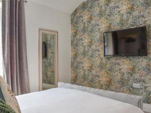 a bedroom with a tv hanging on a wall at Hyde Away - Uk50212 in Scarborough +9 photos