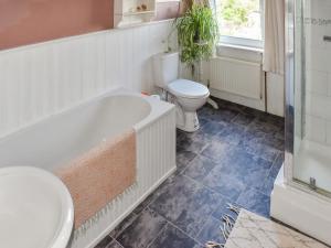 a bathroom with a tub and a toilet and a sink at Skipper's Rest in East Cowes