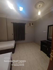 a small room with a bed and a television at نوارة المنسك للشقق الفندقية in Abha +3 photos