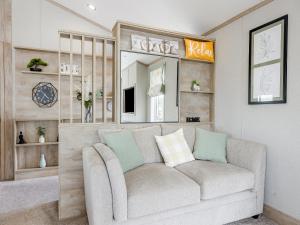 a living room with a couch and a mirror at Hillfort Lodge in Llanrhystyd
