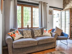 a living room with a couch and windows at Byre Cottage - Uk50028 in Liskeard
