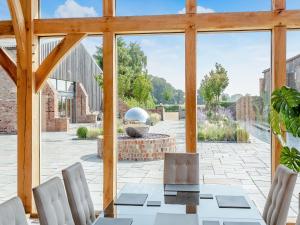 een eetkamer met een tafel en stoelen en een groot raam bij Oakwood Barn in Cawood