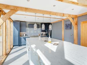 een keuken met een wit aanrecht en blauwe muren bij Oakwood Barn in Cawood