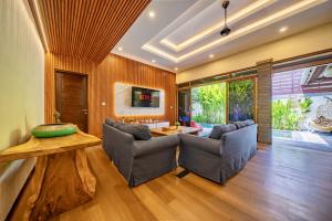 a living room with two chairs and a table at Seminyak Happy Villa in Legian
