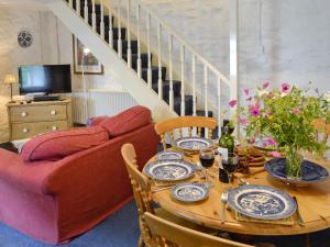 a dining room with a table and a couch at Riverside Cottage in Betws-y-coed