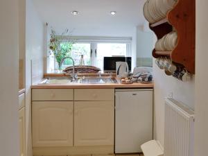 a kitchen with a sink and a window at Riverside Cottage in Betws-y-coed