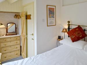 a bedroom with two beds and a dresser and a mirror at Riverside Cottage in Betws-y-coed +8 photos