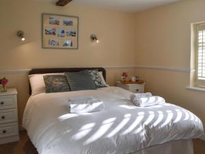 Un dormitorio con una cama con dos almohadas encima. en Garden Cottage, en Rottingdean