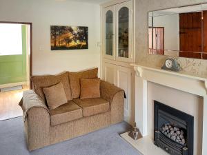 a living room with a couch and a fireplace at Rogue Cottage in Wheldrake