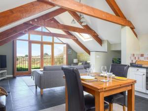 a kitchen and living room with a wooden table and chairs at The Roost in Saint Breward