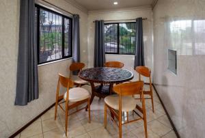 a dining room with a table and chairs and windows at A1 Homestay in Suva +7 photos