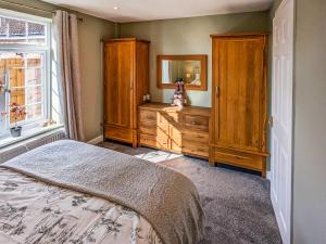 ein Schlafzimmer mit einem Bett, einer Kommode und einem Spiegel in der Unterkunft Magnolia Cottage in Thirsk
