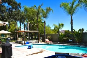 a swimming pool with palm trees in the background at La Casita Poolside Retreat in Lake Elsinore