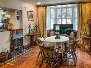 a living room with a table and a fireplace at The Old Lodge in Tisbury