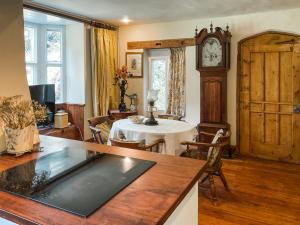 a living room with a table and a grandfather clock at The Old Lodge in Tisbury +16 photos