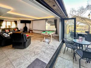 a living room with a ping pong table at Coombe Wood Coach House in Hawkinge