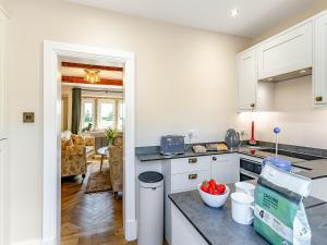 a kitchen with white cabinets and a counter top at May Cottage in Luddenden Foot