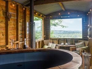 una grande vasca da bagno in una stanza con una grande finestra di Bracken Hut At Copy House Hideaway a Earby