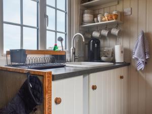 una cucina con un lavello e un piano di lavoro di Bracken Hut At Copy House Hideaway a Earby Altre 11 foto