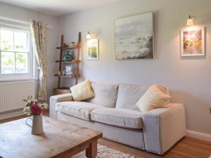Una sala de estar con un sofá y una mesa de café. en Hafan Fach Cottage, en Pembroke