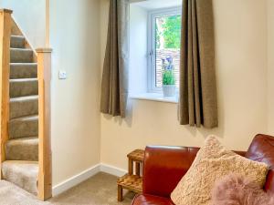 a living room with a couch and a window at The Old Posthouse Barn - Uk50191 in Badgworth