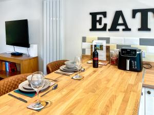 a table with glasses and a bottle of wine on it at The Old Posthouse Barn - Uk50191 in Badgworth