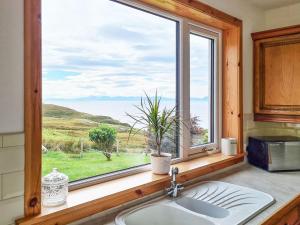 a sink in a kitchen with a large window at Sunny Hill - Ukc6884 in Aultgrishin +10 photos