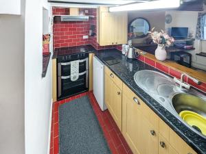 a small kitchen with a sink and a stove at Wee Cottage in Paignton
