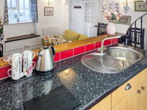 a kitchen counter with a sink in a kitchen at Wee Cottage in Paignton
