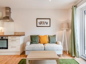 a living room with a couch and a table at Dairy Cottage-Ukc5158 in Shootend