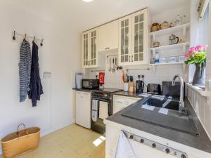 a kitchen with white cabinets and a sink at Island Cottage in West Mersea