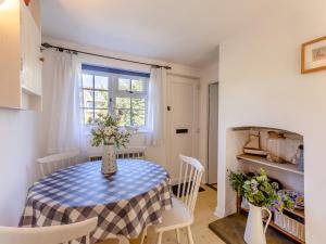 a kitchen and dining room with a table and chairs at Island Cottage in West Mersea