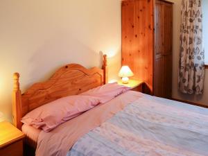 a bedroom with a bed with a wooden head board at Horsemans in John O Groats