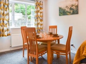 a dining room with a table and chairs and a window at Oaklea Cottage in Windermere