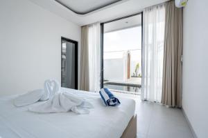 a white bed in a room with a large window at Ruana Villa Pererenan in Munggu +43 photos