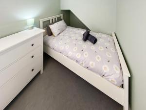 a small bedroom with a white bed and a dresser at Low Tide - Uk50362 in Filey