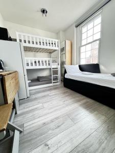 une chambre avec deux lits superposés et un plancher en bois dans l'établissement London Duo & Quad Rooms in Zone 2 - Willesden Green, à Londres