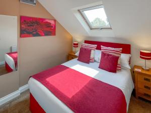 una camera con un letto rosso e bianco e una finestra di Lauras Loft - Uk49740 a Fulletby
